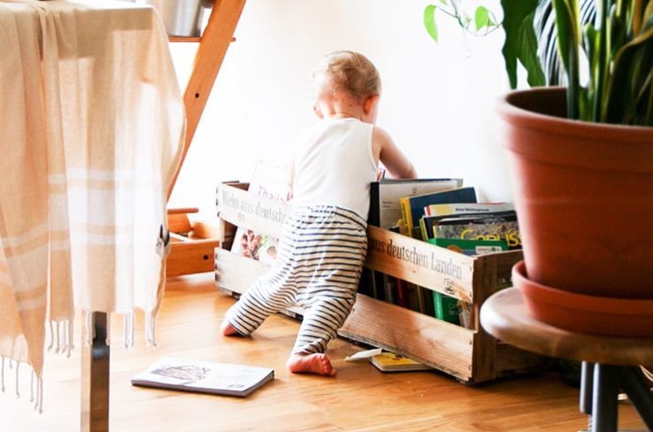 child picking up books on kid-friendly flooring
