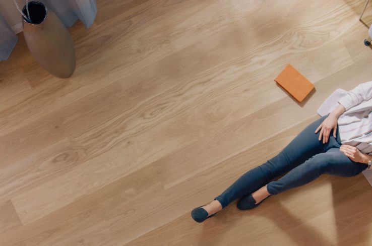 A women sitting on newly laid flooring.