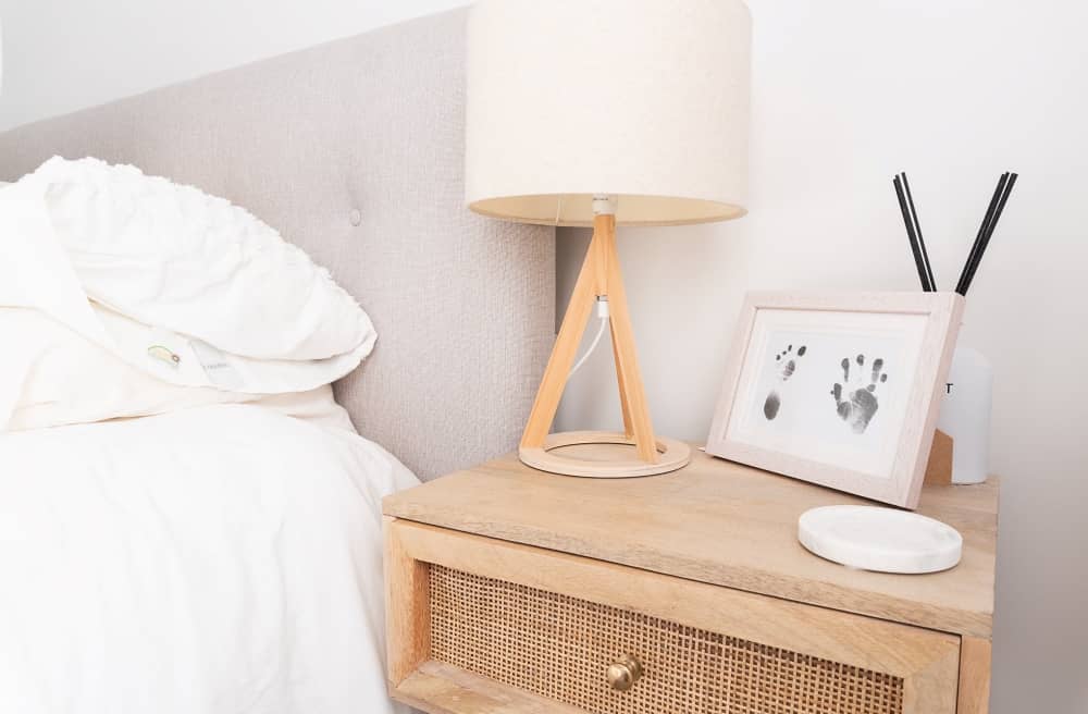 Bedside table with lamp and frame.