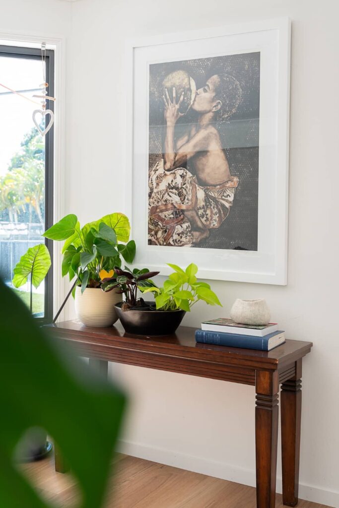 Plants and books on hallway console.