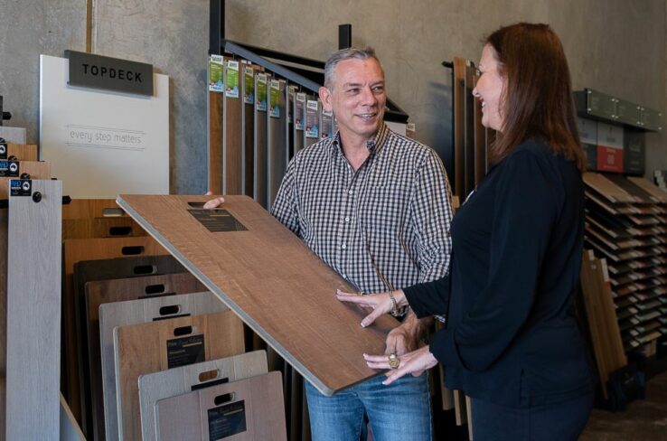 Man explaining flooring features to customer.