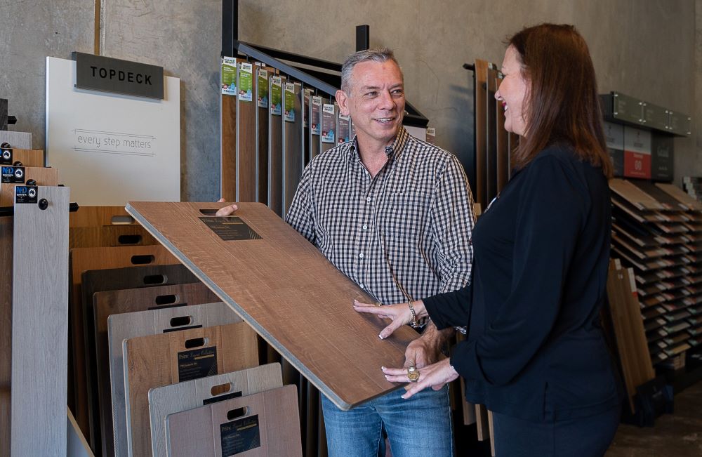 Man explaining flooring features to customer.