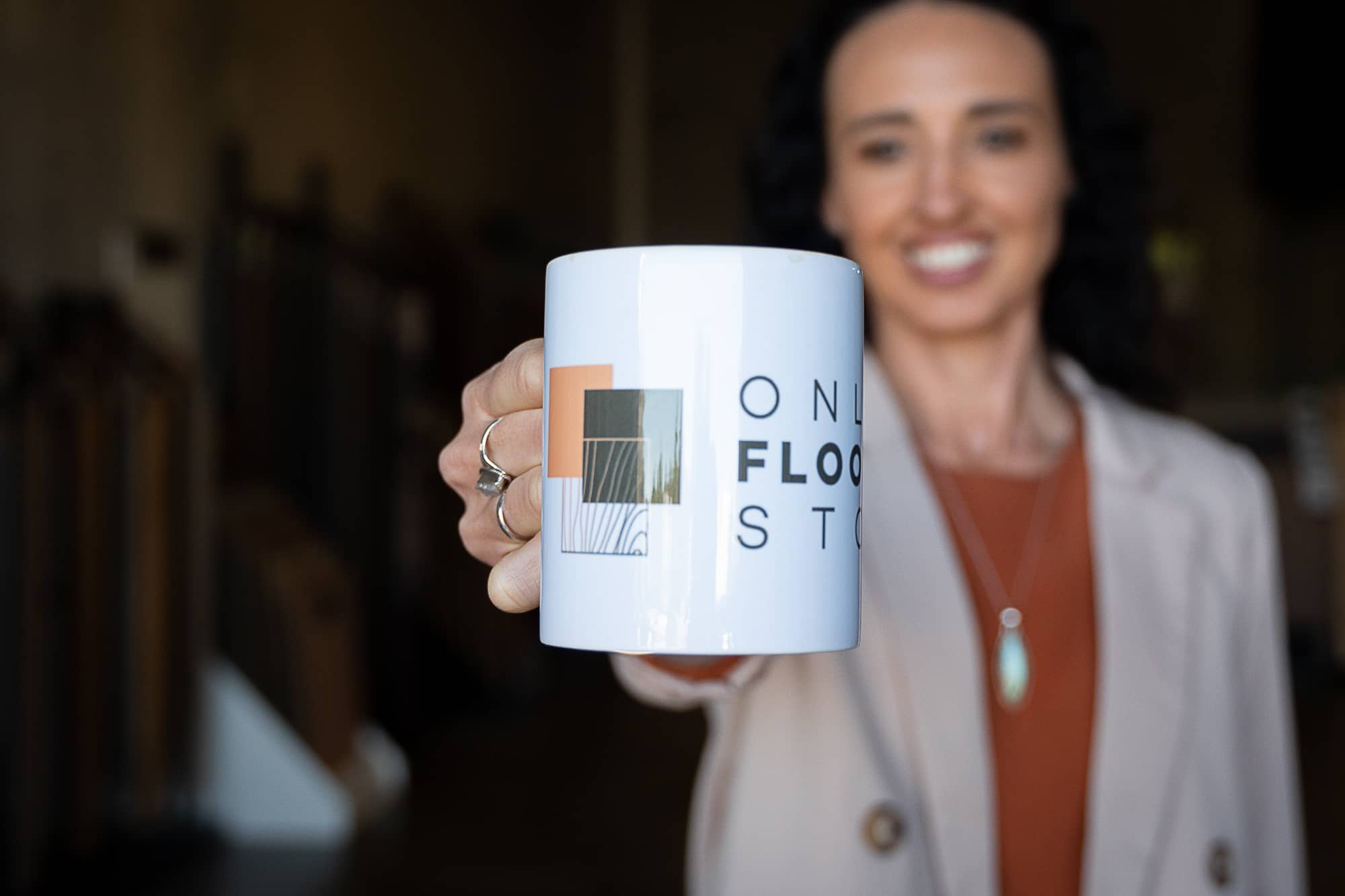 Raquel holding up a Online Flooring Store mug.