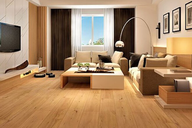 Contemporary living room with warm honey-toned Airstep Eucalyptus Steps XL large-format longboard laminate flooring, neutral sofas, a low coffee table, arched floor lamp and framed wall art.