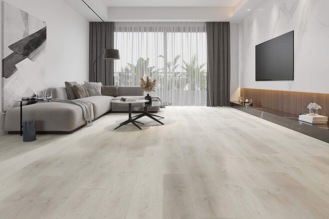 Spacious modern living room showcasing pale Forest Oak AirStep Keeta laminate flooring, with a grey L-shaped sofa, minimalist coffee table, marble feature wall and floor-to-ceiling windows.