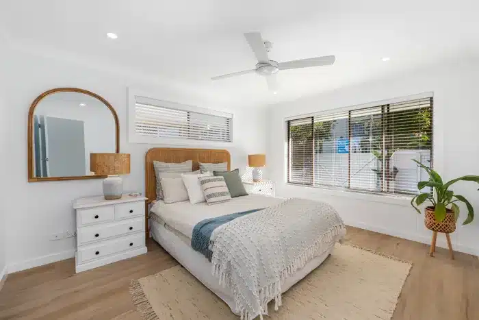 Renovated duplex bedroom with neutral tones, timber flooring and natural light