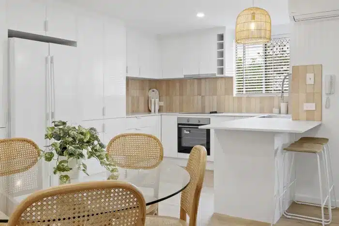 Modern Tweed Heads duplex kitchen with white cabinetry, timber accents and dining area